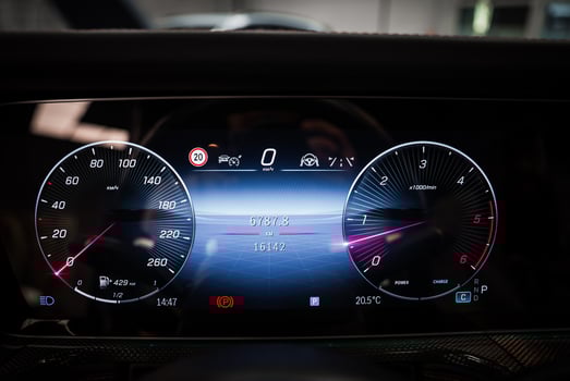 Detailed view of a Mercedes AMG digital instrument cluster showing speedometer, tachometer, mileage, and driving data in a sleek indoor environment. photo