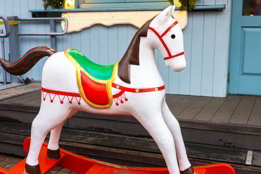 Colorful wooden rocking horse at a festive location with holiday decorations in the background photo