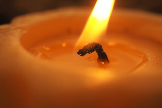 Candle flickering softly in a dimly lit setting photo