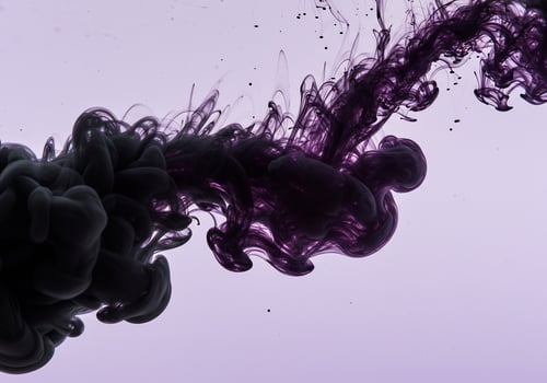 Billowing cloud of deep purple ink swirling elegantly through pale lavender water. photo