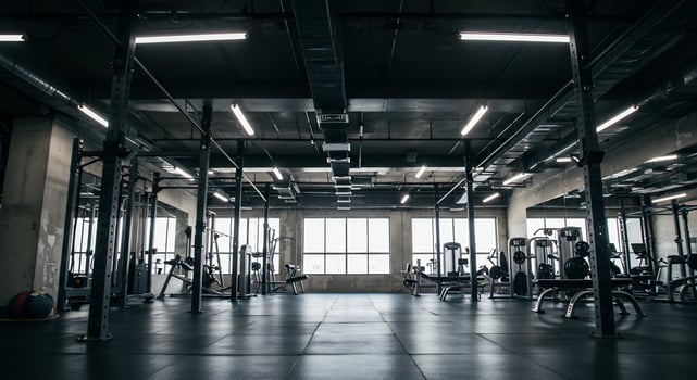 Raw industrial gym interior with exposed ceiling, concrete walls, and modern equipment. photo