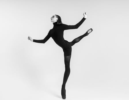 young ballerina, in a black dress and sunglasses total black, makes an attitude. photo