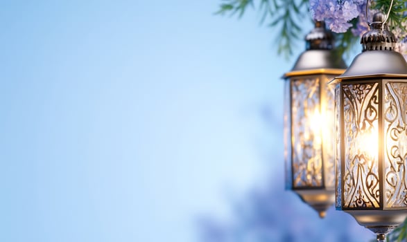 Glowing lanterns with floral accents on light blue background photo