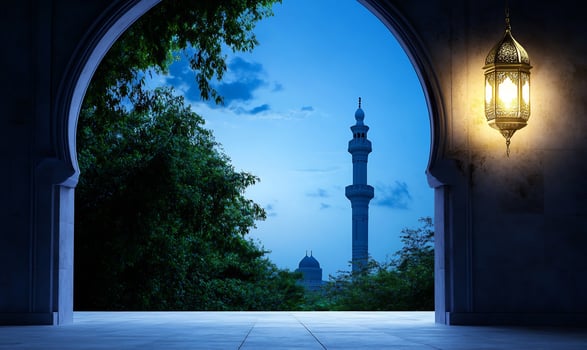 Architectural archway with minaret and glowing lantern against a blue sky at dusk photo