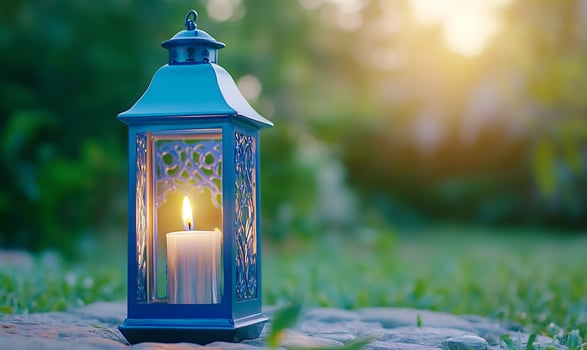 Blue candle lantern with candlelight on stone outdoor background photo