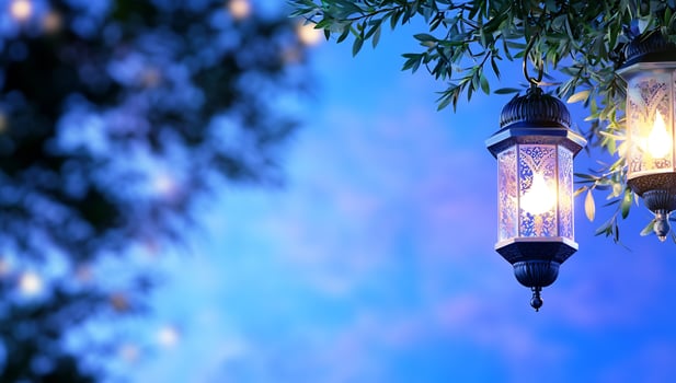 Decorative lanterns hanging from tree branches in soft blue light photo