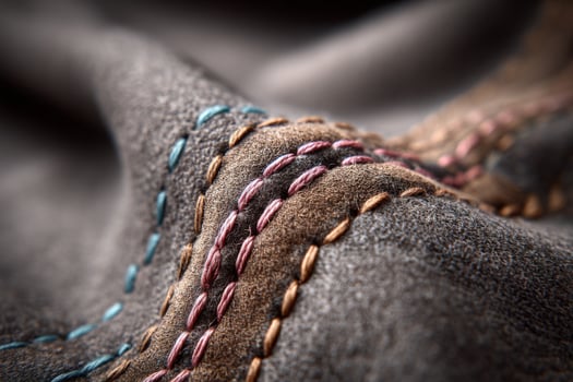 Closeup of a piece of leather with colorful stitching photo