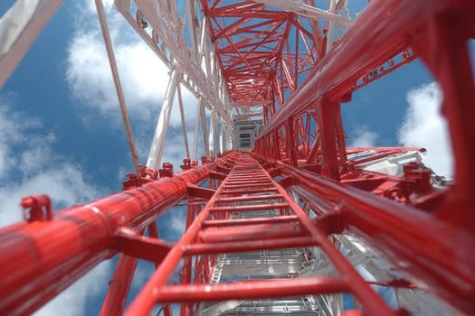 A red ladder is on top of a tall tower photo