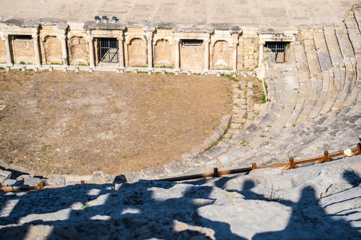 Ancient hierarchical city structure a woman exploring the historical amphitheater ruins on a sunny day with stone seats. photo