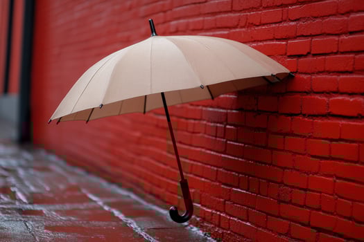 Beige umbrella leaning red brick wall, rainy alley photo