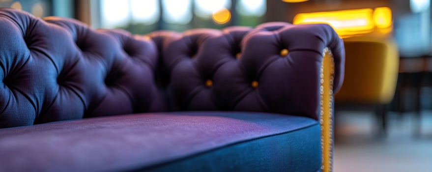 Purple tufted sofa in modern lounge, blurred background photo