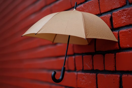 Beige umbrella hanging brick wall, rainy day, protection concept photo