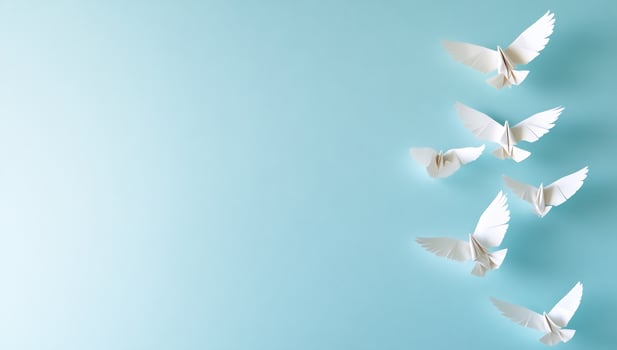 Origami birds on light blue background symbolic paper bird art and craft concept photo
