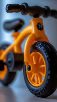 Orange balance bike, indoor studio shot, blurred background, child's toy photo