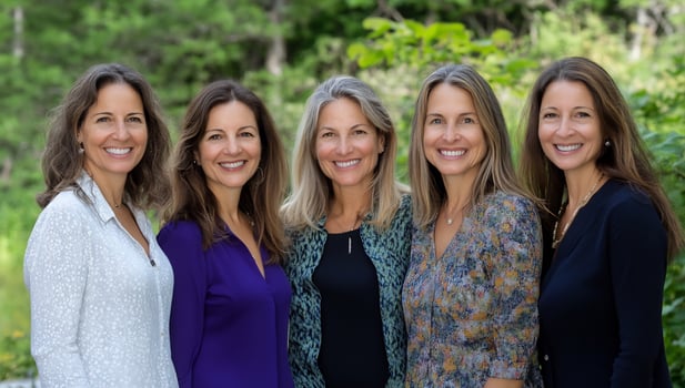 Group portrait of five smiling women in an outdoor setting with natural lighting photo