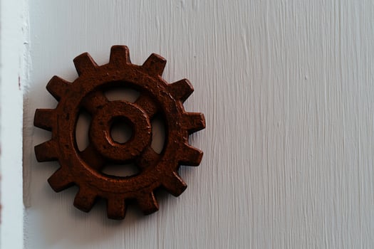 Rusty gear on white wood, copy space, industrial background photo