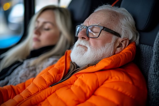 Elderly man and woman sleeping on vehicle, winter travel photo