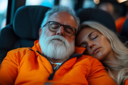 Couple sleeps soundly on bus, travel fatigue, blurred background, transportation photo