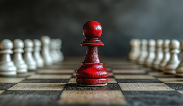 Red Pawn Stands out Amidst White Pieces on a Chessboard in a Strategic Game Setting photo