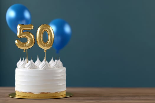 Celebration cake with foil balloon numbers and blue balloons for special occasion photo
