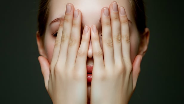 Person hiding face behind hands expressing emotion photo