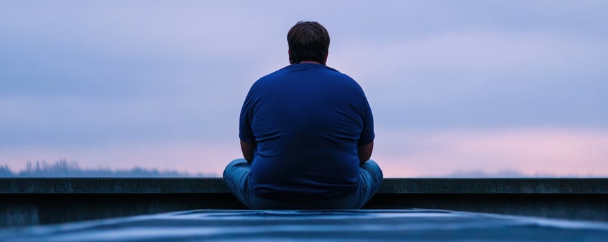 Obese man sits alone, cityscape background, contemplation, health photo