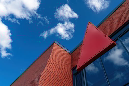 Red triangle sign, brick building, blue sky, clouds, architecture design photo