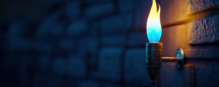 Blue flame torch on wall, dark brick background. Game design photo