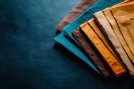 Colorful handmade papers stacked, dark background, design texture, craft photo