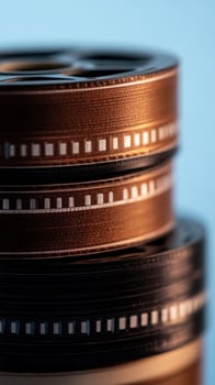 Film reels stacked, studio backdrop, closeup, nostalgic media photo