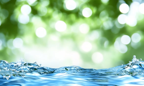 Clear blue water surface with abstract green background photo