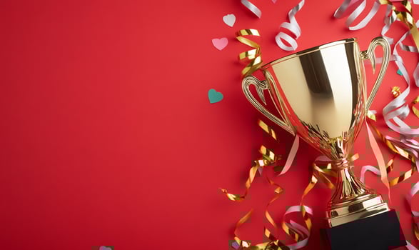 Gold trophy celebration with ribbons confetti on red festive background photo