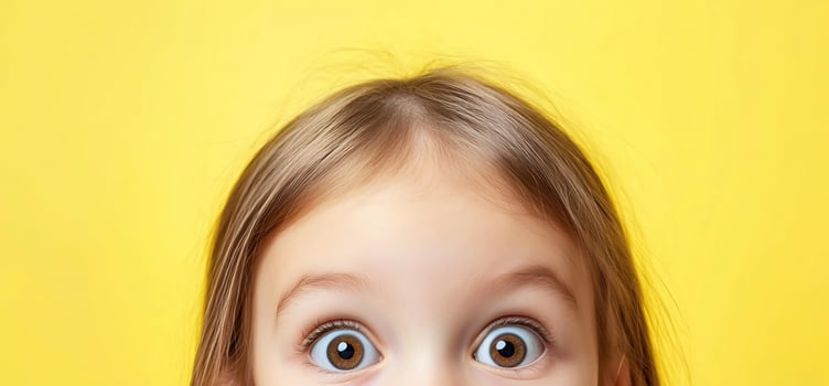 Child portrait with surprised expression against yellow background photo