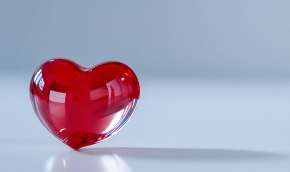 Red heart glass shape on smooth surface abstract still life background photo