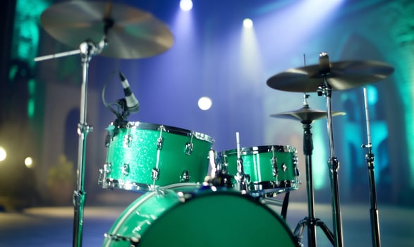 Green drum set under bright stage lights for musical performance photo
