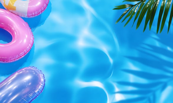 Summer pool floating and sunlight reflection on water surface with tropical palm leaf photo