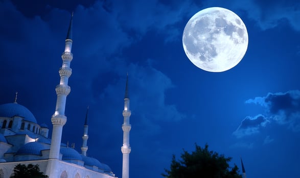 Architectural building with towers and full moon at night sky photo