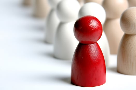 Leadership concept with a red wooden figure standing out from the crowd photo
