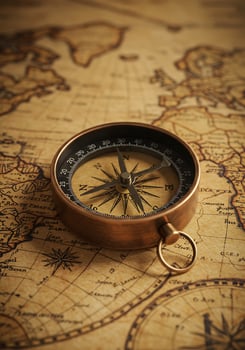 A vintage compass on an old world map photo