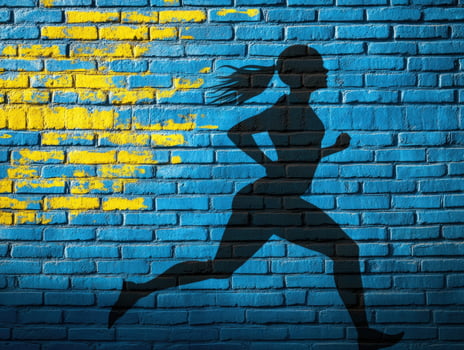 Woman runner silhouette, urban brick wall, Ukraine flag, athletic energy photo