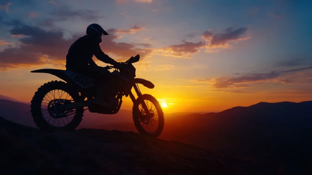 Motocross rider sunset mountaintop silhouette photo