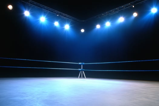 Empty boxing ring under bright spotlights stage for competition photo