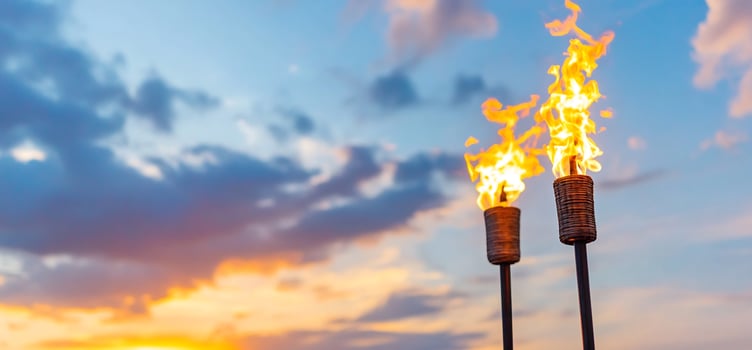 Tiki torches against sunset sky flames decorative illumination for tropical party background photo