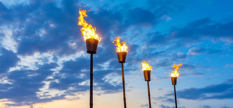 Tiki torch flame against sky background warm light celebration and outdoor decor photo