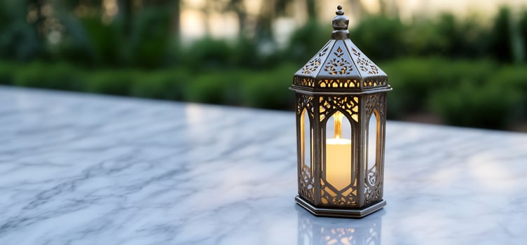 Ornamental lantern with candlelight on marble surface photo