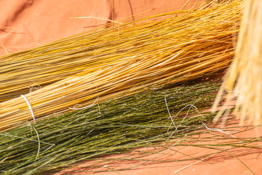 The raw materials for a handmade craft with dyed yellow and green straw artisan workshop concept photo