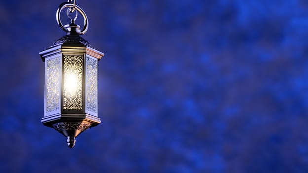 Ornate metal lantern with warm light hanging on chain against blue texture background photo