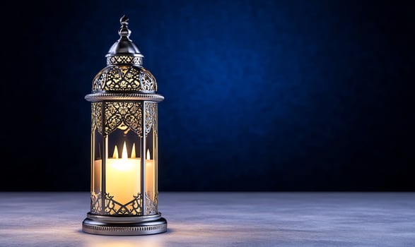 Ornate candle lantern with intricate design against dark blue backdrop for decorative and holiday use photo