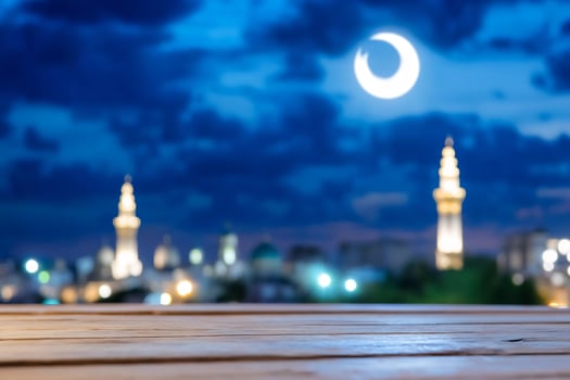 City skyline under crescent moon with empty wooden table at night photo