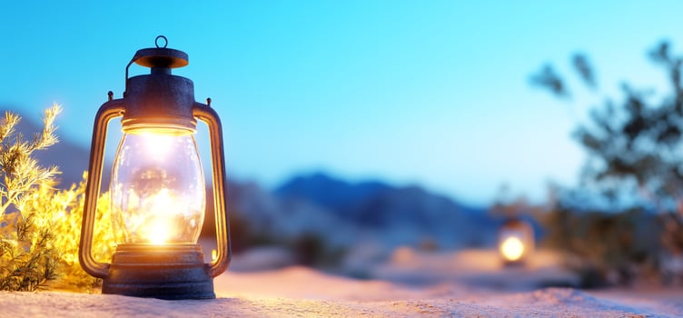 Vintage lantern illuminates desert landscape at dusk photo